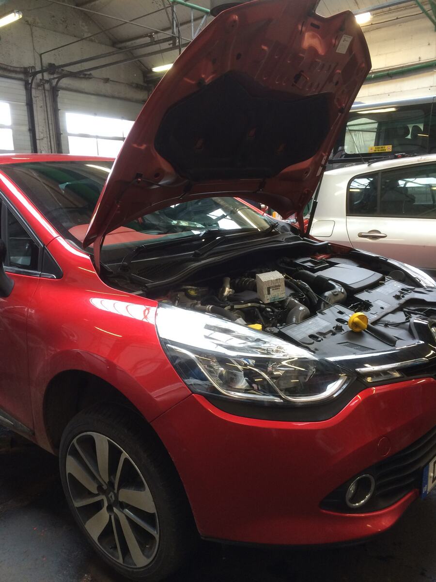 Red Renault Clio with the bonnet open in the workshop