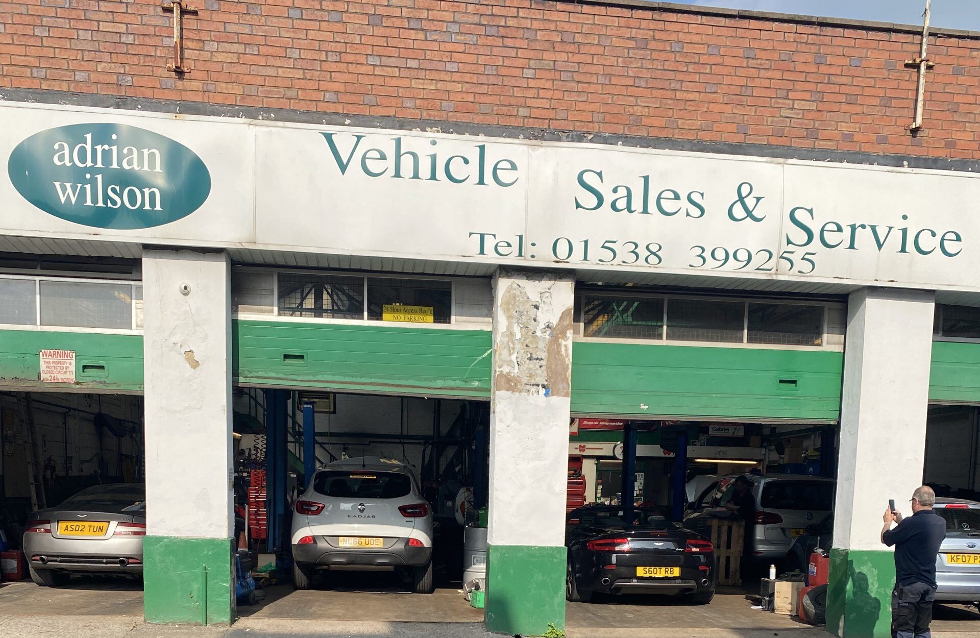 The Adrian Wilson Garage shopfront on Salisbury Street, Leek, with its green shutters and open workshop bays