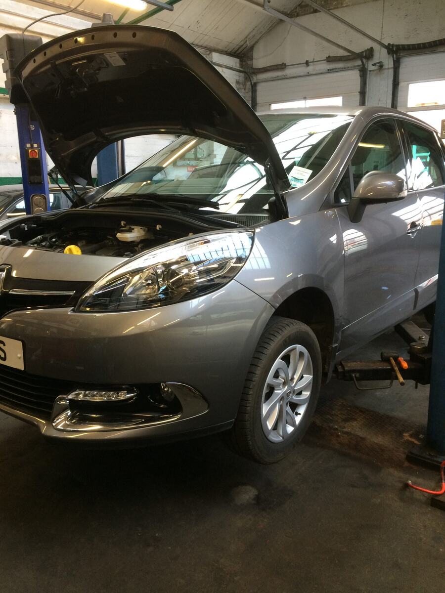 Renault Scénic raised on a lift in the workshop with its bonnet open
