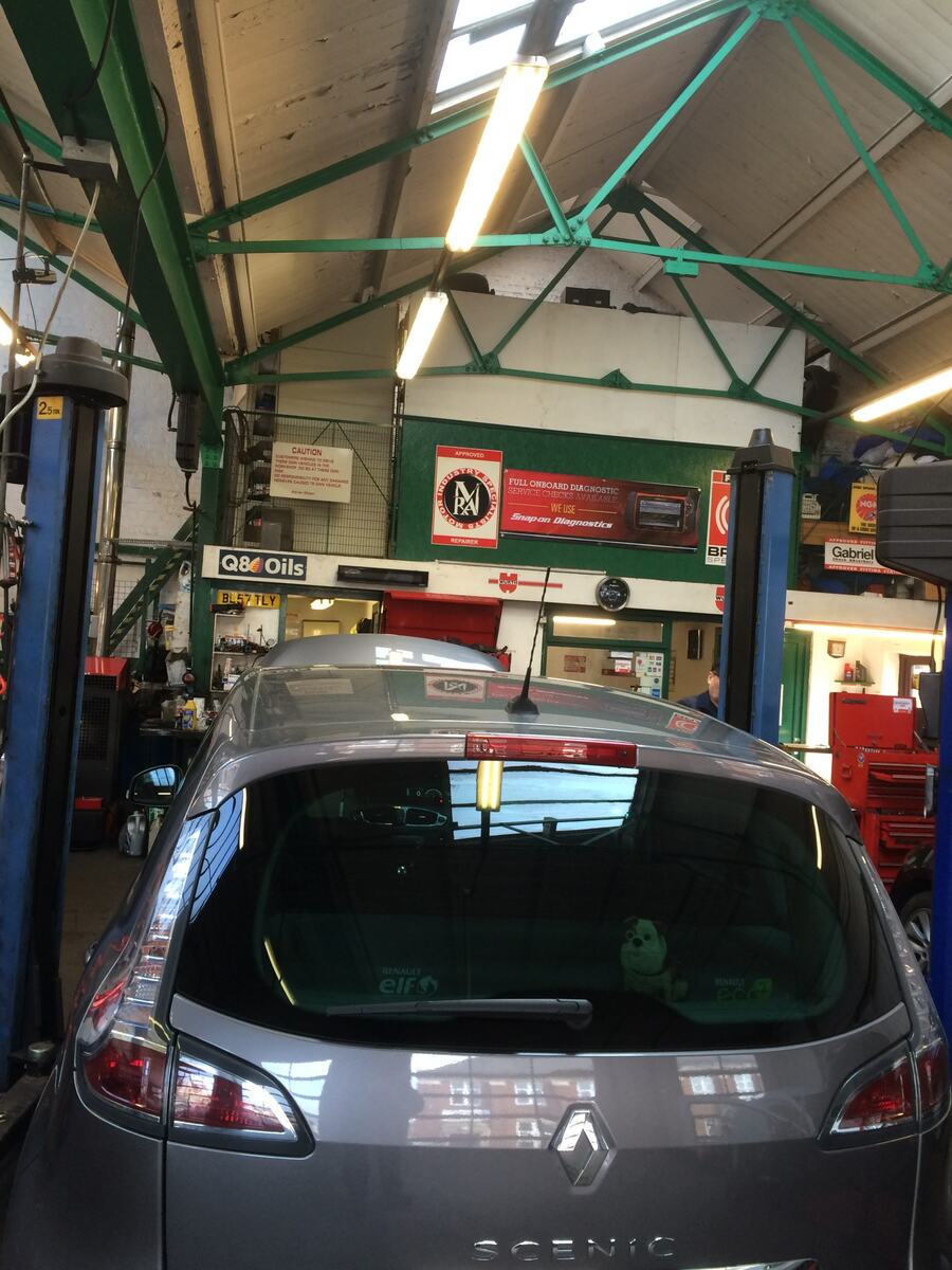 Rear of a Renault Scénic inside the workshop, with lifts and tools
